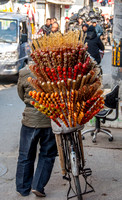 Delivering sugar-coated fruit on a stick from the local market.